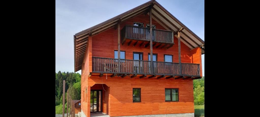 a large wooden house with a balcony on top at Casa Catalin in Gura Humorului