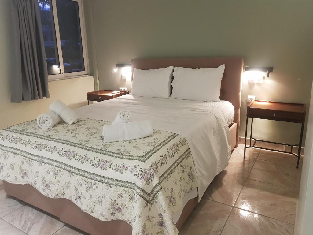 a bedroom with a bed with two towels on it at Limonero New City Apartment 2 with Private Parking in Lefkada Town
