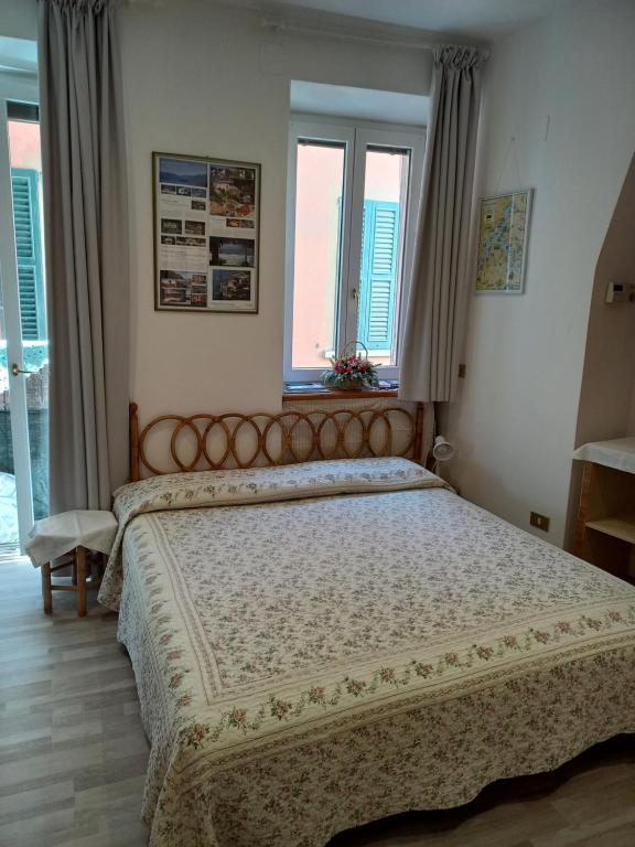 a bedroom with a large bed and two windows at Bellagio Center Apartment n°12 in Bellagio