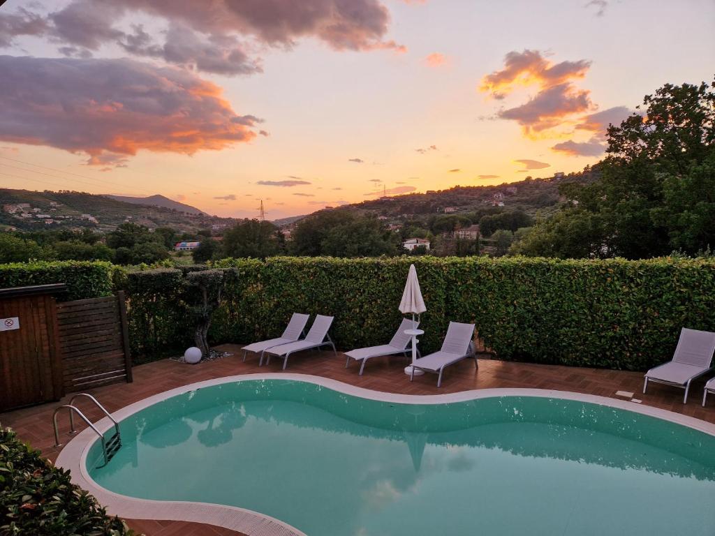 una piscina con sillas y una puesta de sol en el fondo en B&B Artemide, en Agropoli