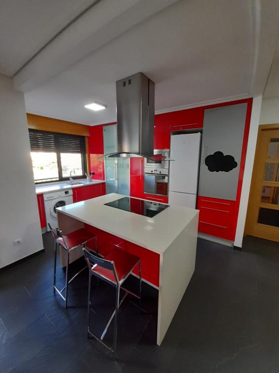 a kitchen with red walls and a white counter top at PISO NUEVO EN MOAÑA in Moaña
