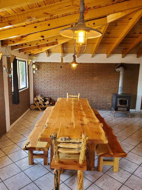 una gran mesa de madera en una habitación con fogones en Hostal Pata de Perro en Creel