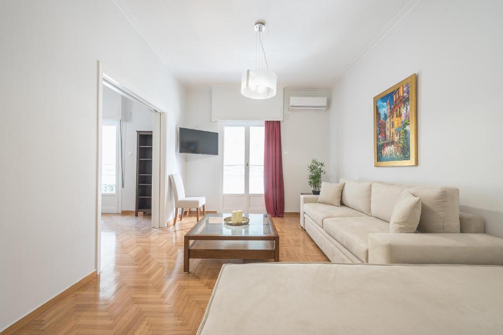 - un salon avec un canapé et une table dans l'établissement Victoria Best Apartments, à Athènes