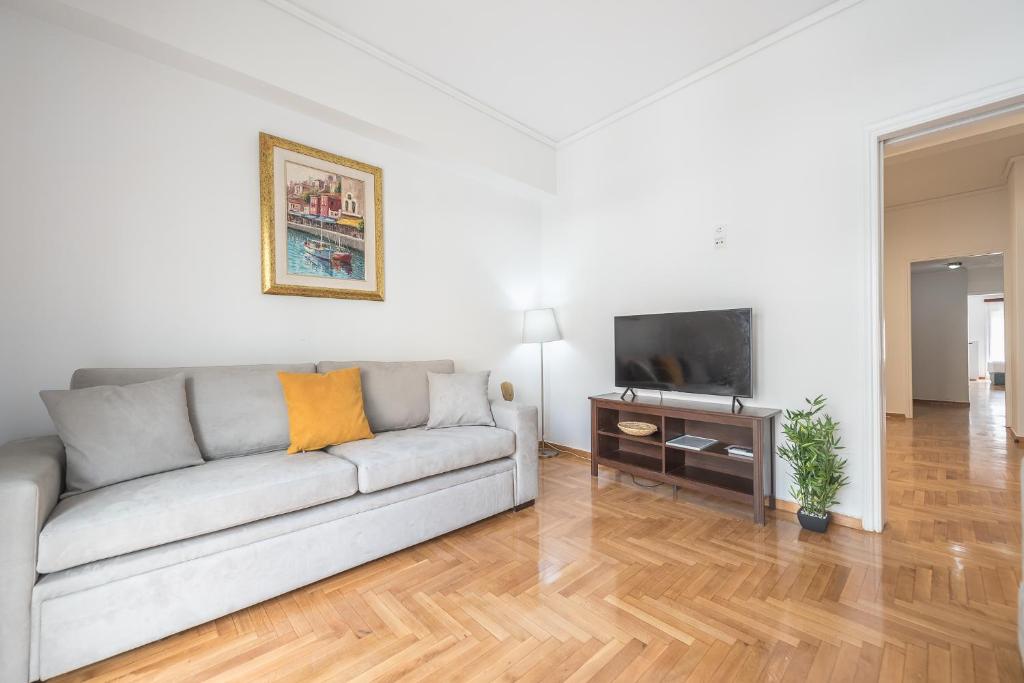 a living room with a couch and a television at Victoria Secret Apartments in Athens