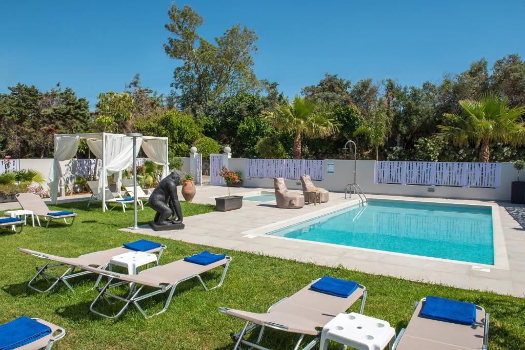 un cortile con piscina e sedie a sdraio e una piscina di Marianthi Apts by Estia a Platanes