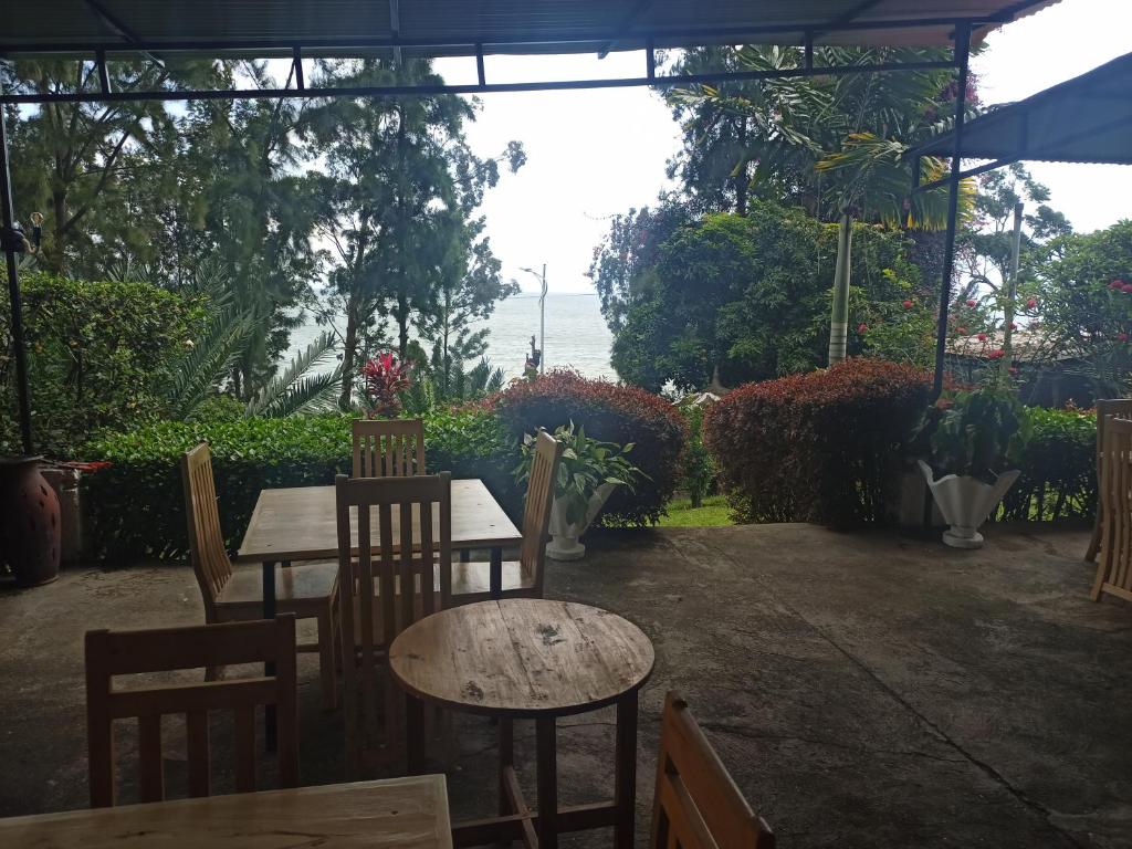 um pátio com duas mesas, cadeiras e plantas em Maddy's Kitchen and Accomodation em Gisenyi