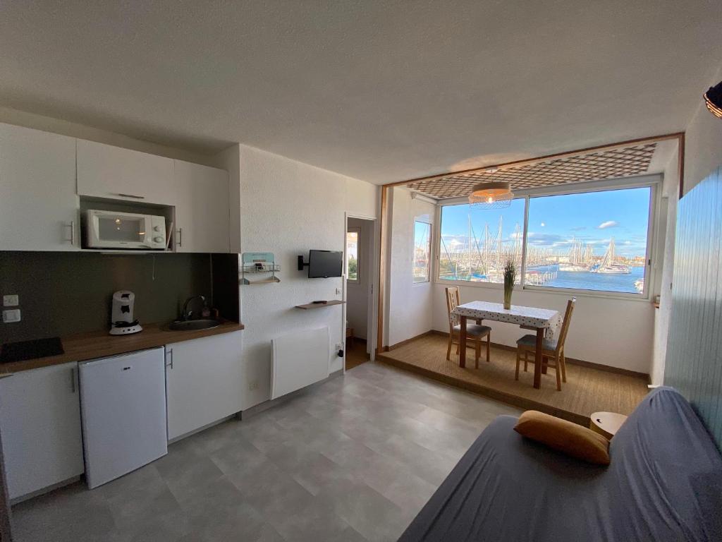 a kitchen and dining room with a view of the ocean at LE COCON DE LA MARINA in Leucate
