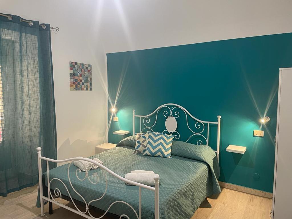 una camera con un letto con una parete blu di Casa Vittoria a Palermo