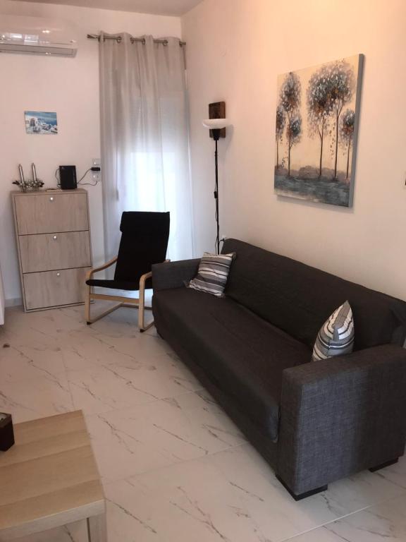 ein Wohnzimmer mit einem schwarzen Sofa und einem Tisch in der Unterkunft Cozy apartment with two bedrooms with a sea view in Peraia
