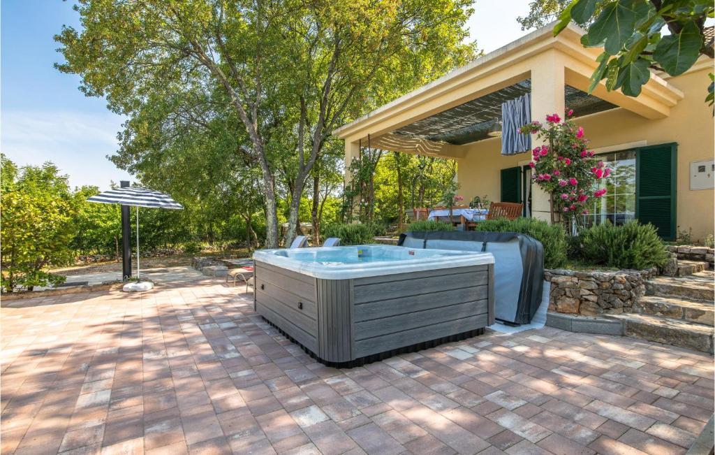 a hot tub on a patio in front of a house at Stunning Home In Ostrobradic With 2 Bedrooms, Jacuzzi And Wifi in Sveti Anton