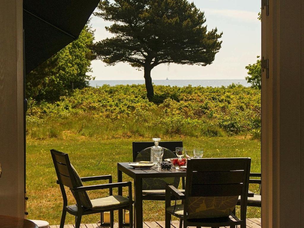 a table and chairs with a table and a tree at Seaside Spa Retreat - By Traum Ferienwohnungen in Hals