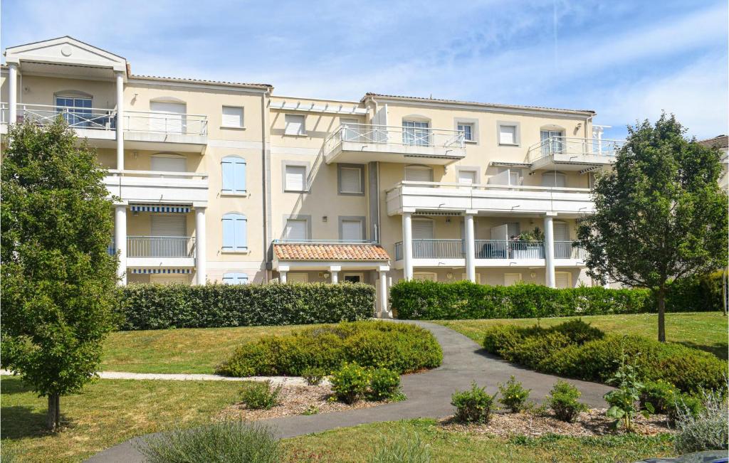 a large apartment building with a garden in front of it at Amazing Apartment In Vaux-Sur-Mer in Vaux-sur-Mer