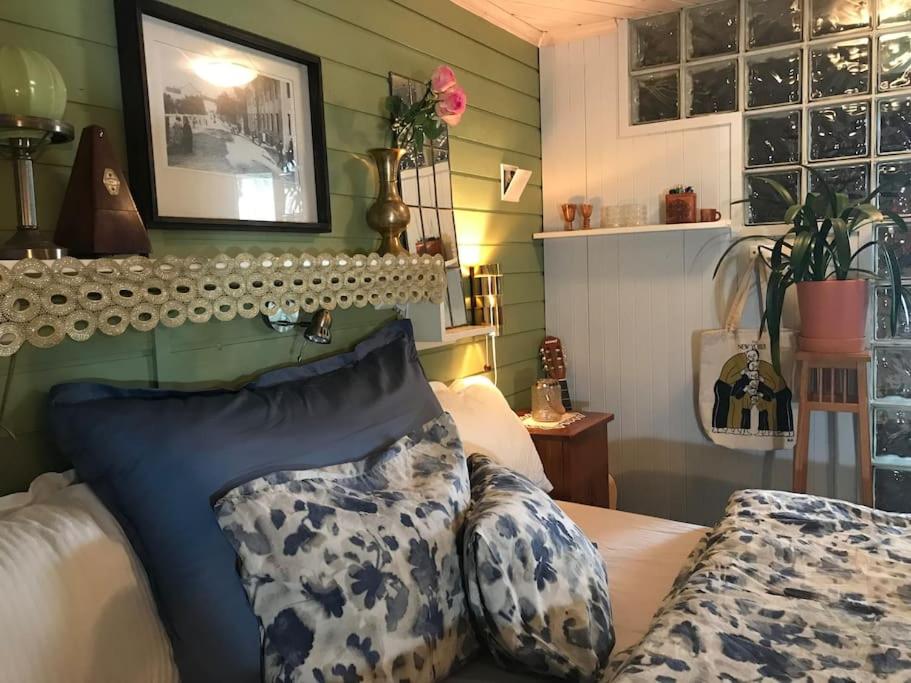 Charming studio with private patio في ستافانغر: غرفة نوم مع سرير ووسائد زرقاء وبيضاء