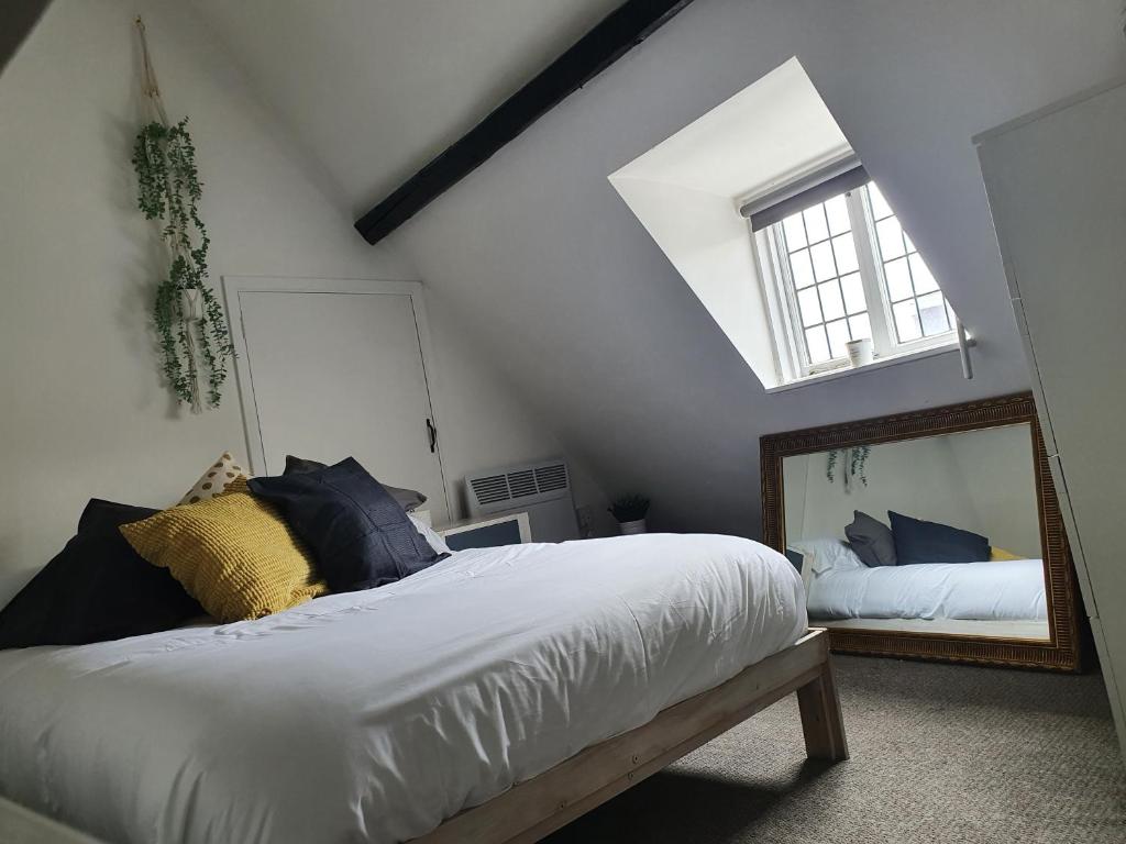 Grade I listed luxury apartment in Hertfordshire في وار: غرفة نوم بسرير كبير ومرآة