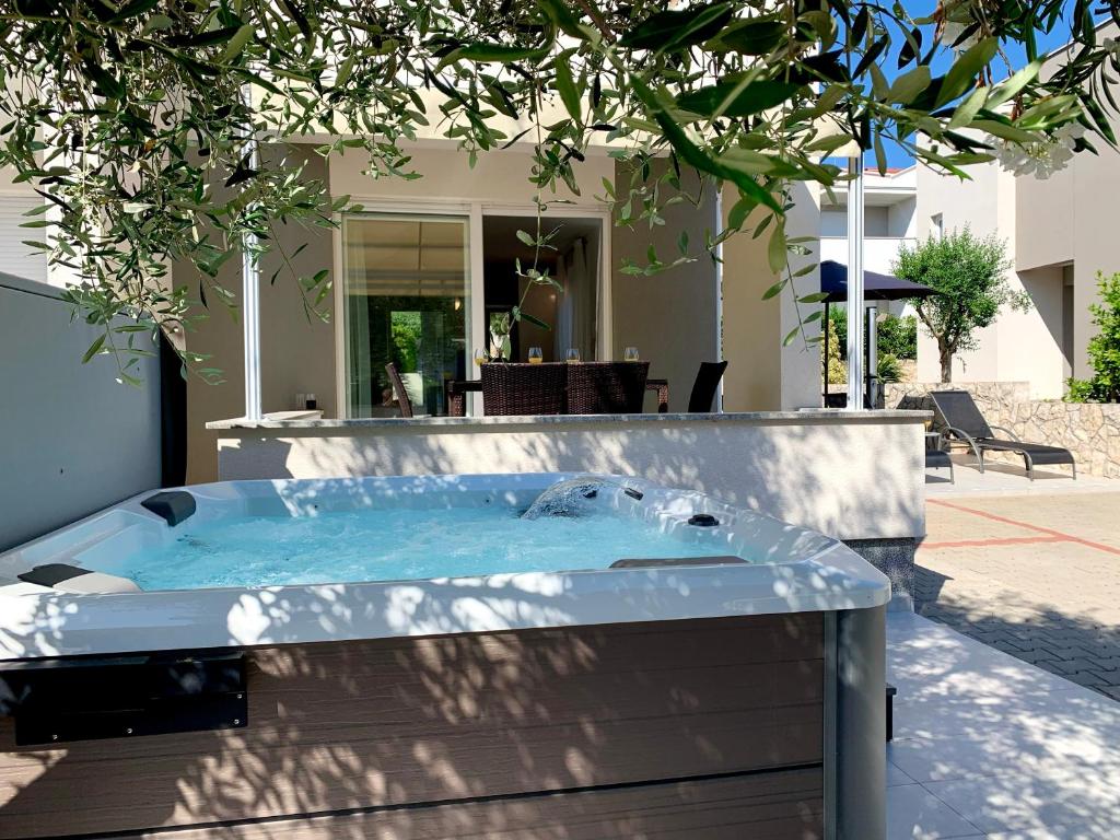 a hot tub in front of a house at Fantasy Classic Maisonette II in Novalja