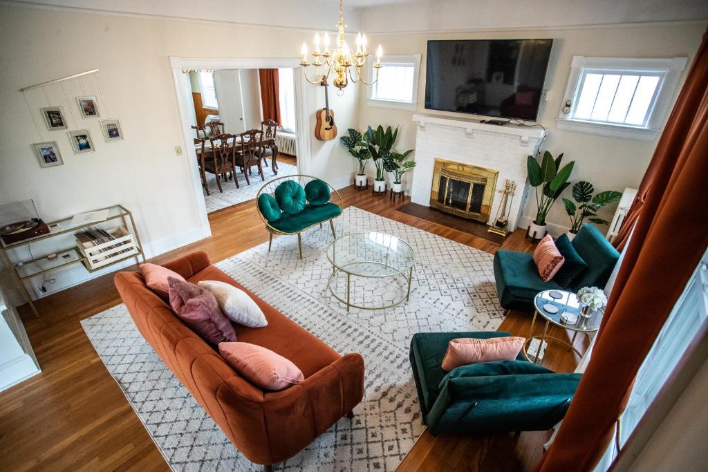 ein Wohnzimmer mit einem Sofa, Stühlen und einem Kamin in der Unterkunft Charming 1932 Craftsman - The Bohannon House in Luray