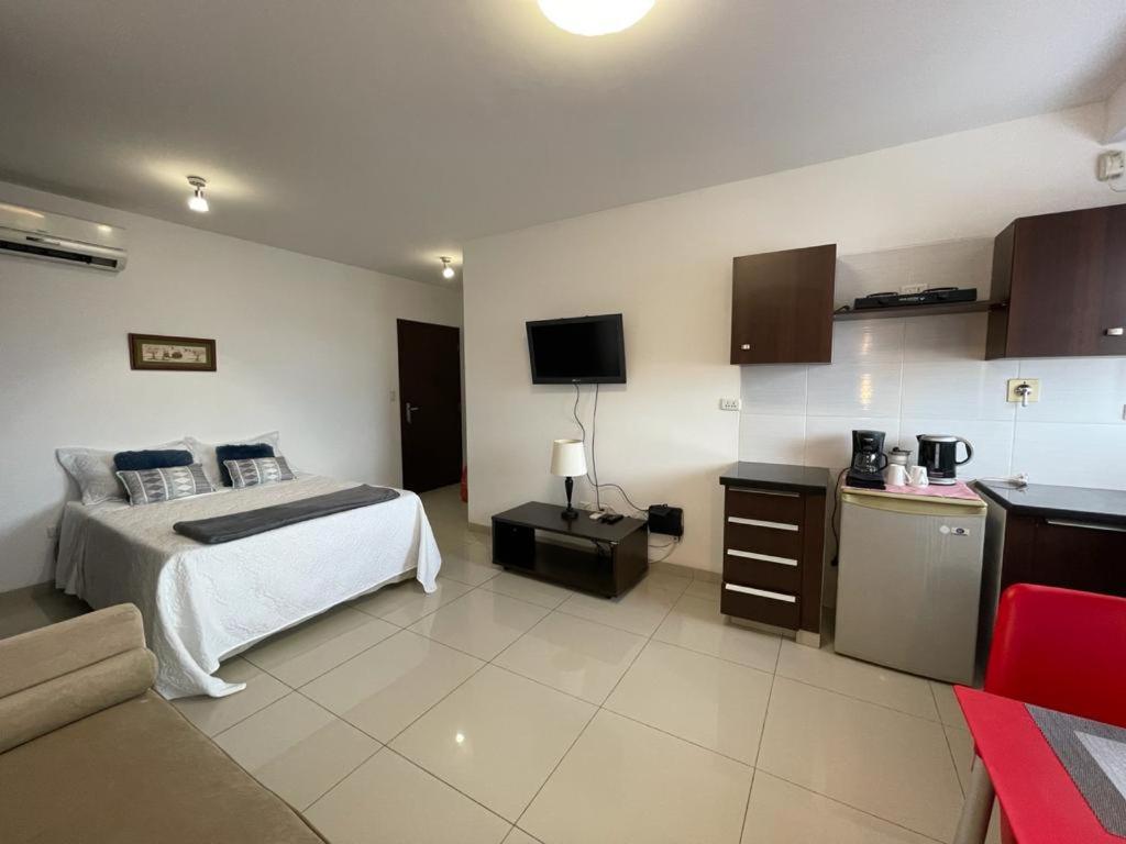 ein Hotelzimmer mit einem Bett und einer Küche in der Unterkunft Cómodo y tranquilo monoambiente equipado in Santa Cruz de la Sierra