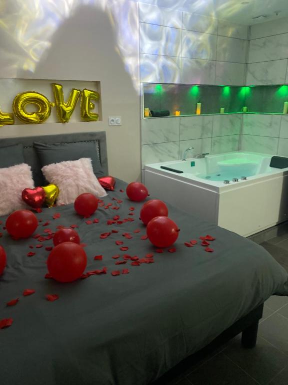 una camera con un letto e una vasca con fiori rossi di Lov’SPA a Fleury-Mérogis
