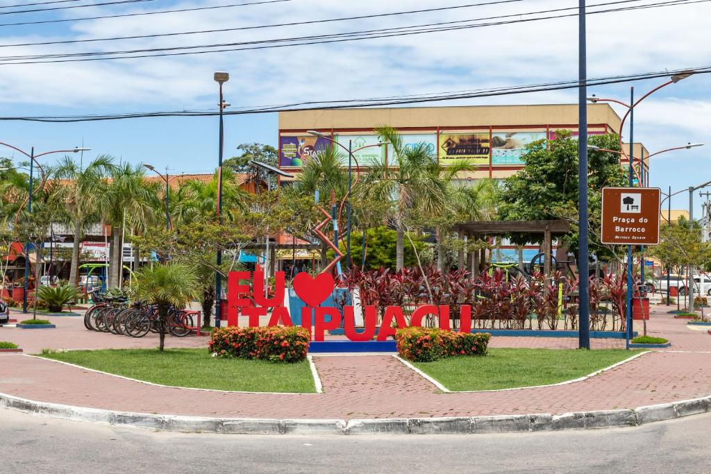 a sign in front of a building on a street at Studio Aconchegante com Varanda garagem Tv Smart Wi-fi in Maricá