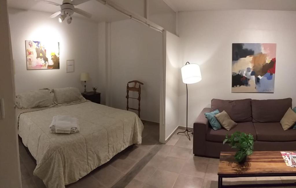 sypialnia z łóżkiem i kanapą w obiekcie PUNTO COLON w mieście Mendoza