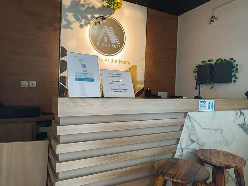 a restaurant with two stools and a counter top at RUMAH KOPI SYARIAH HOTEL in Bandar Lampung