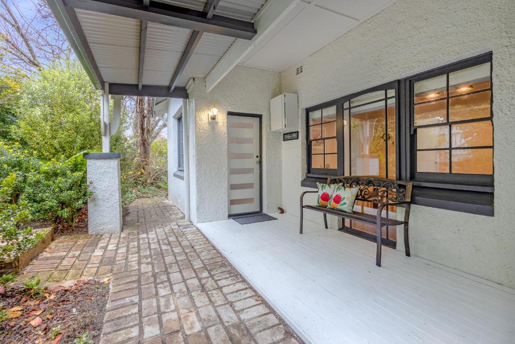 a porch of a house with a bench and a door at Sunshine Cottage in Katoomba