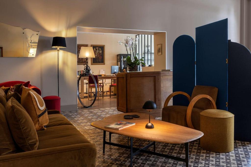 a living room with a couch and a table at Best Western Plus d'Europe et d'Angleterre in Mâcon