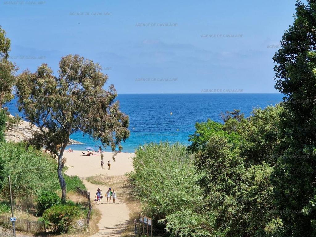 - une plage avec des gens sur le sable et l'océan dans l'établissement Appartement T3 à Cavalaire-sur-Mer - Terrasse vue mer et parking - FR-1-100-271, à Cavalaire-sur-Mer