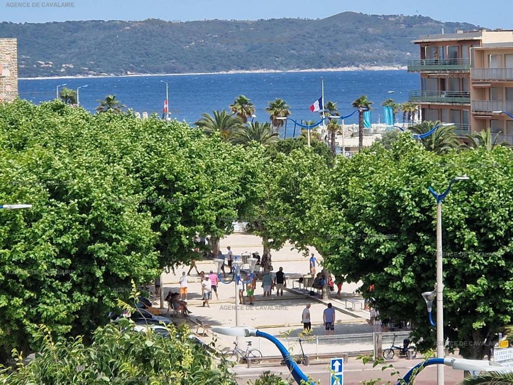 a group of people walking on a beach near the water at T3 au centre de Cavalaire avec parking, clim, wifi, proche plage - FR-1-100-272 in Cavalaire-sur-Mer