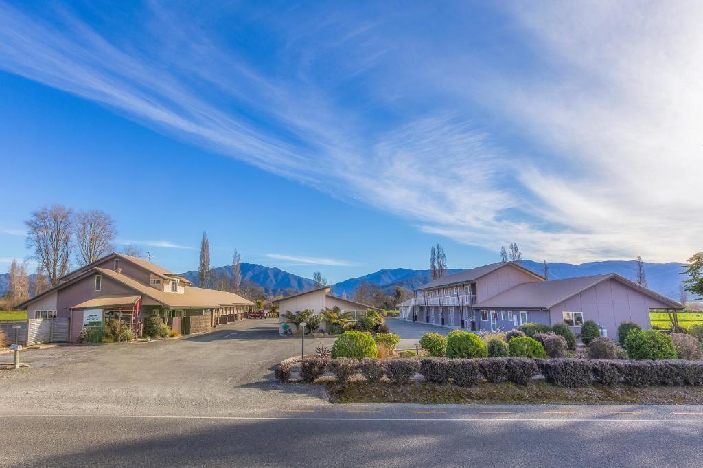 una fila di case con montagne sullo sfondo di Mohua Motels a Takaka