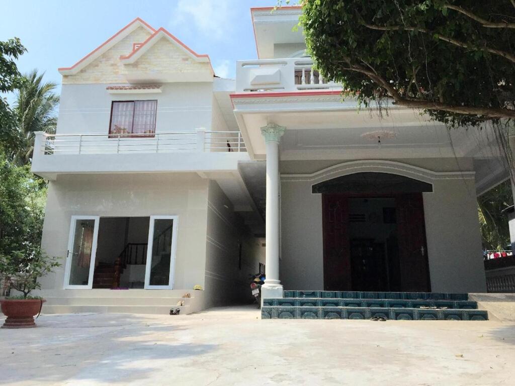 a white house with a gate and a driveway at NHÀ NGHỈ THUỲ NHUNG 1 in Phú Quốc
