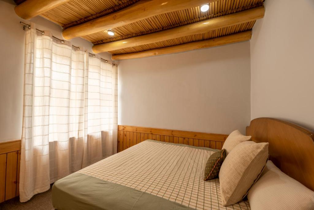 a bedroom with a bed and a window at Primrose Cottage, 1 bhk Villa w garden by Roamhome in Leh