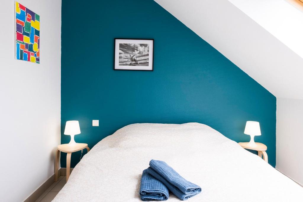 1 dormitorio con 1 cama con pared azul en gîte de l'artiste Segré ✰ T2 confort ✰ centre ✰ 2 lits, en Segré