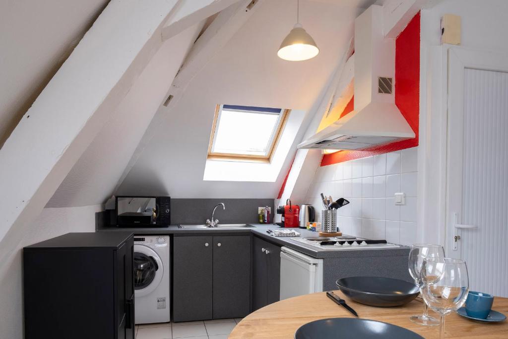 a kitchen with a sink and a washing machine at gîte de l&#39;artiste Segré ✰ T2 confort ✰ centre ✰ 2 lits in Segré