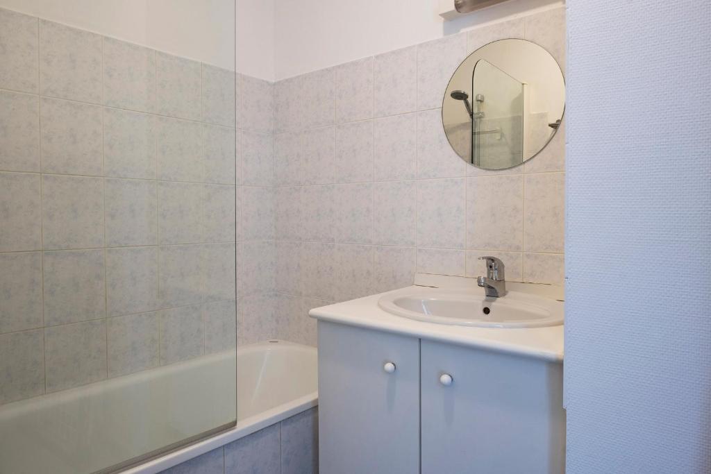 a bathroom with a sink and a mirror and a tub at gîte de l&#39;artiste Segré ✰ T2 confort ✰ centre ✰ 2 lits in Segré
