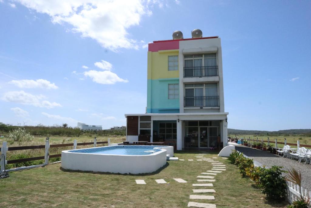 a building with a pool in front of it at Let's Play B&B 七桃旅宿 in Nanwan