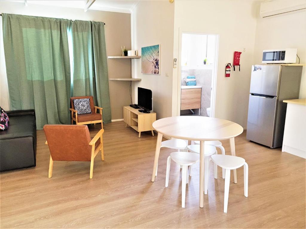 a living room with a table and chairs and a kitchen at Kangaroo Island - Island Beach Shack in Island Beach