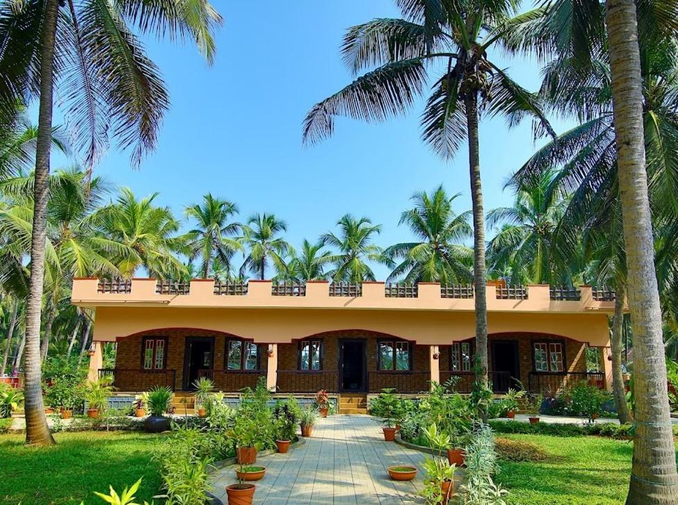 a house with palm trees in front of it at Shimmering View in Kalyānpur