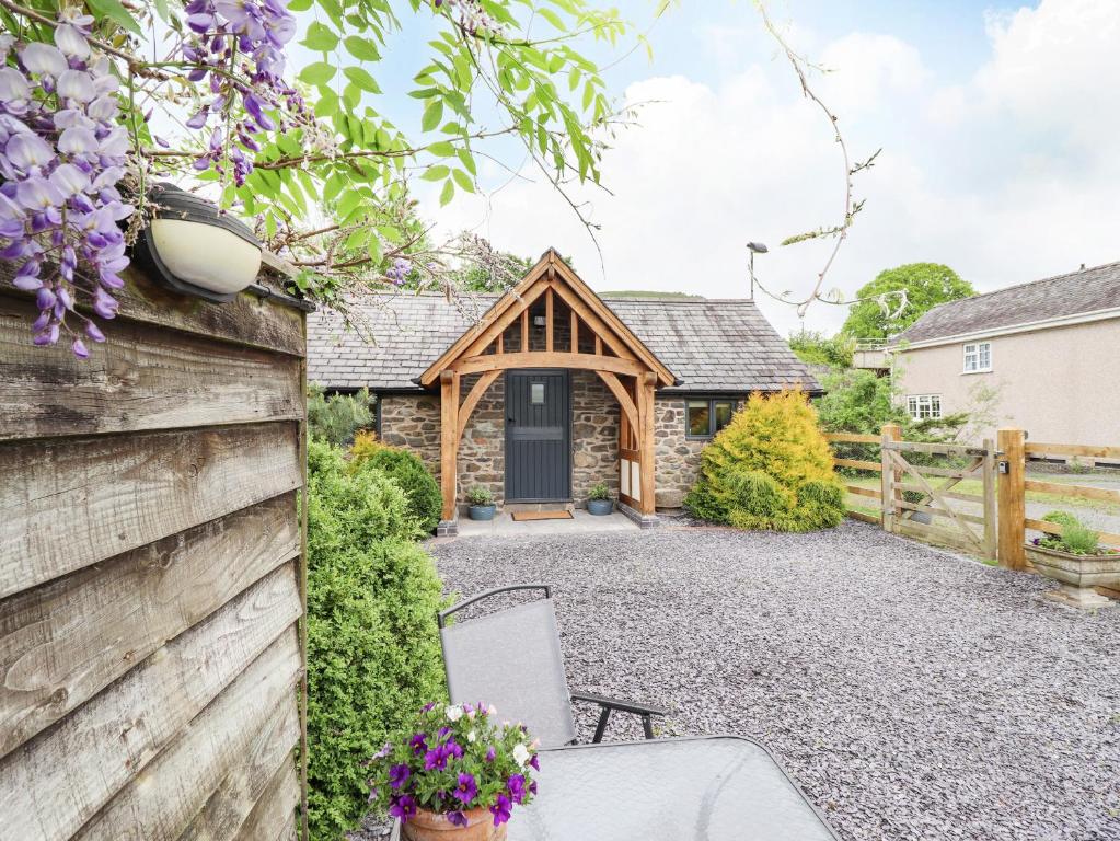 a cottage with a wooden gate and a fence at The Talkhouse Cottage in Caersws