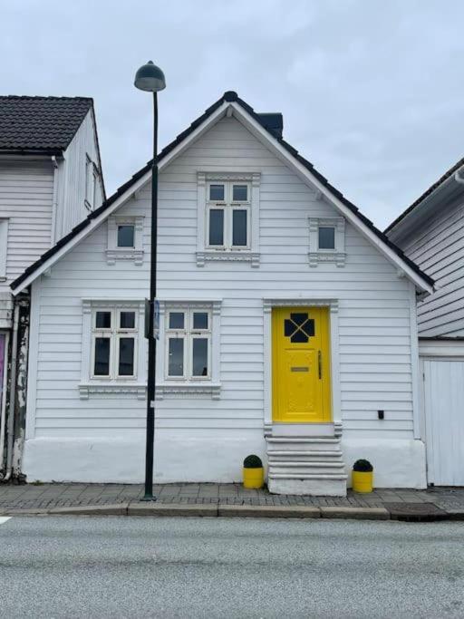 a white house with a yellow door on a street at The yellow door in Stavanger