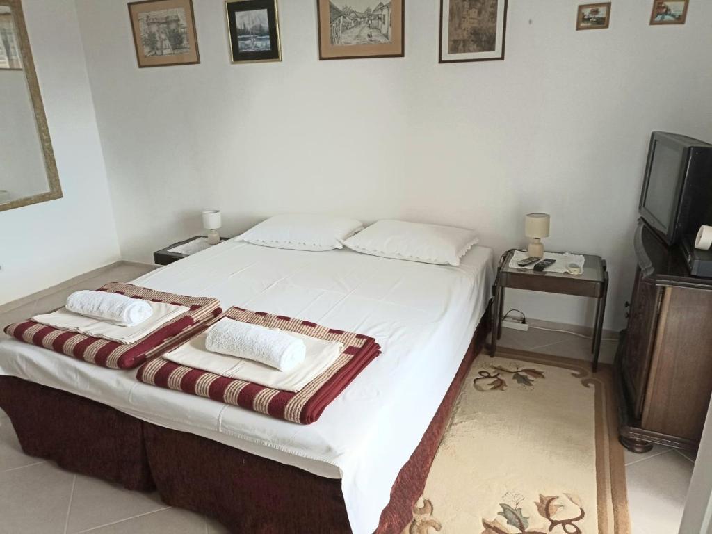 a bedroom with a bed with two pillows on it at Guesthouse Ljilja - apartment with balcony 2 in Meljine