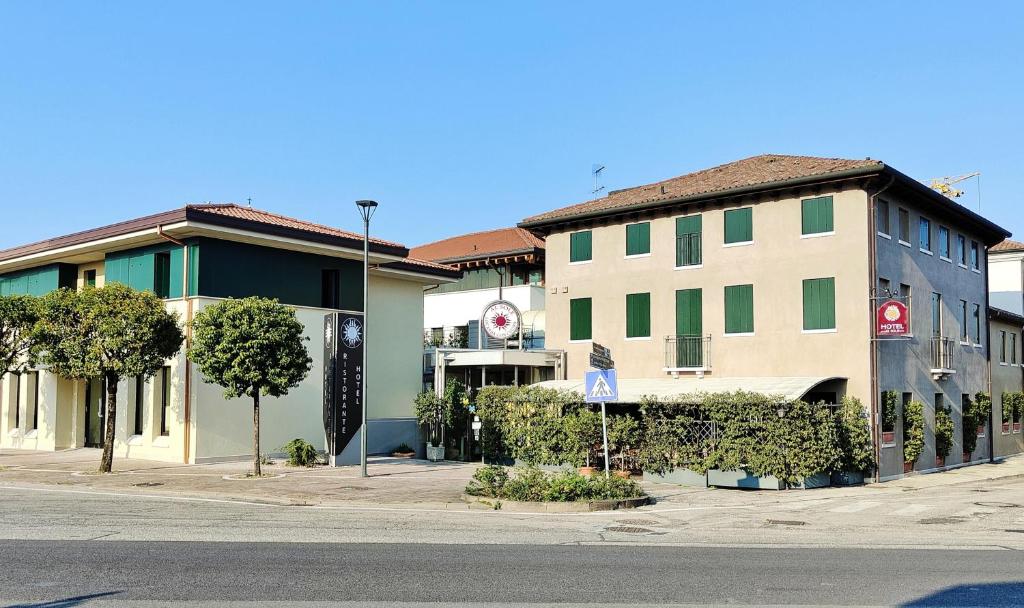 un bâtiment sur le côté d'une rue arborée dans l'établissement Hotel Locanda Al Sole, à Castello di Godego