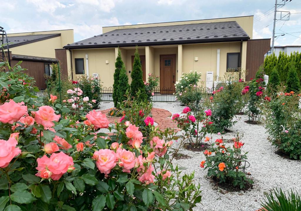 una casa con rosas rosas delante de ella en Hananoyado Yumefuji en Fujikawaguchiko