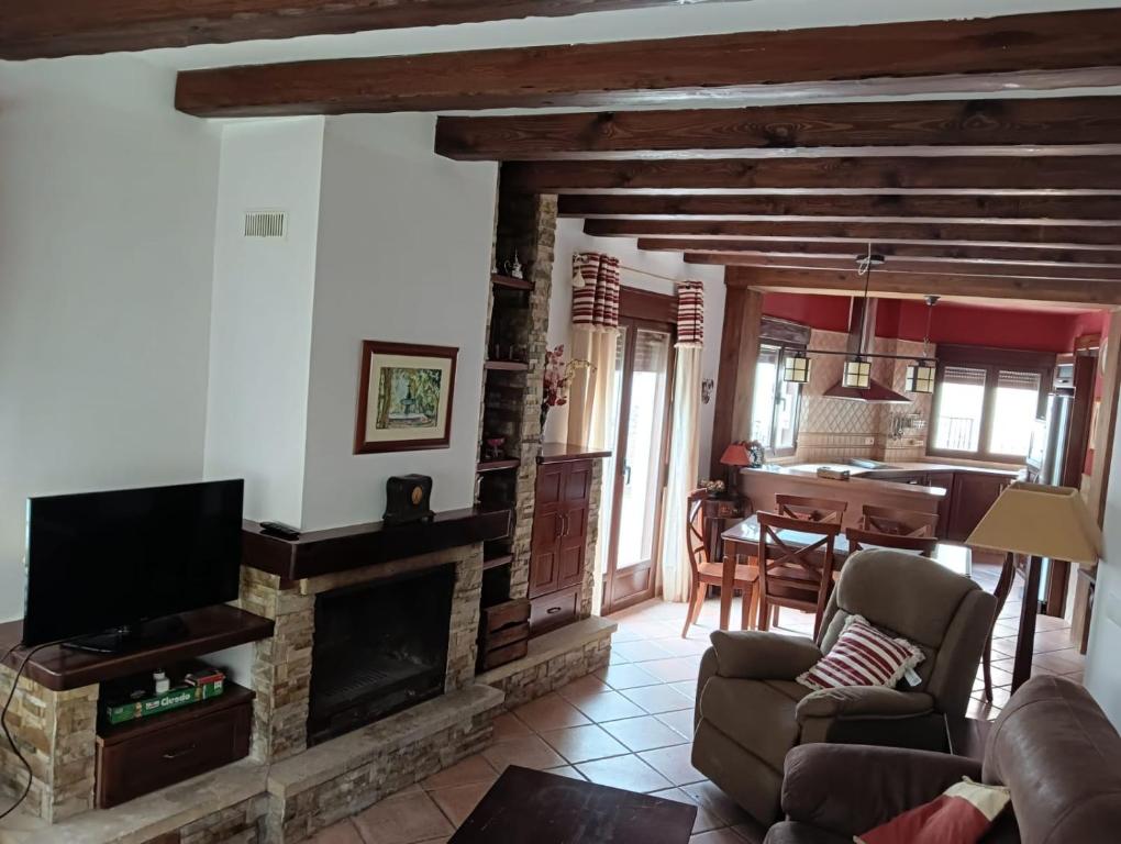 a living room with a fireplace and a tv at Al-Medin in Trevélez