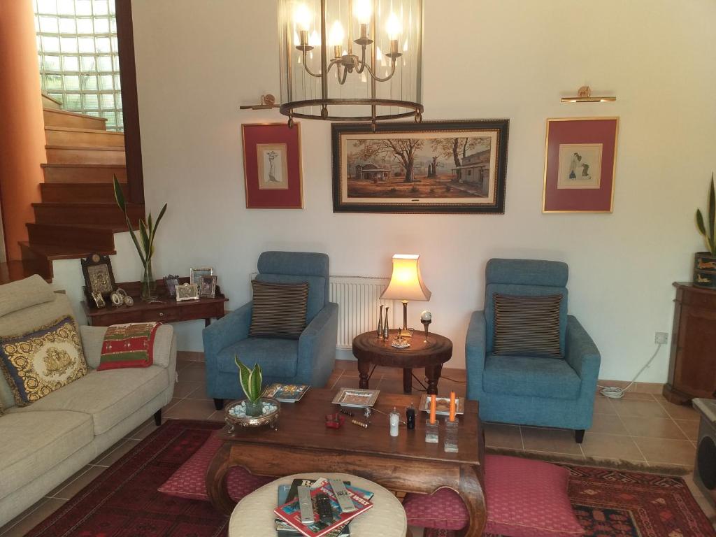 un soggiorno con divano, sedie e tavolo di Residence L' Aubrais a Limassol