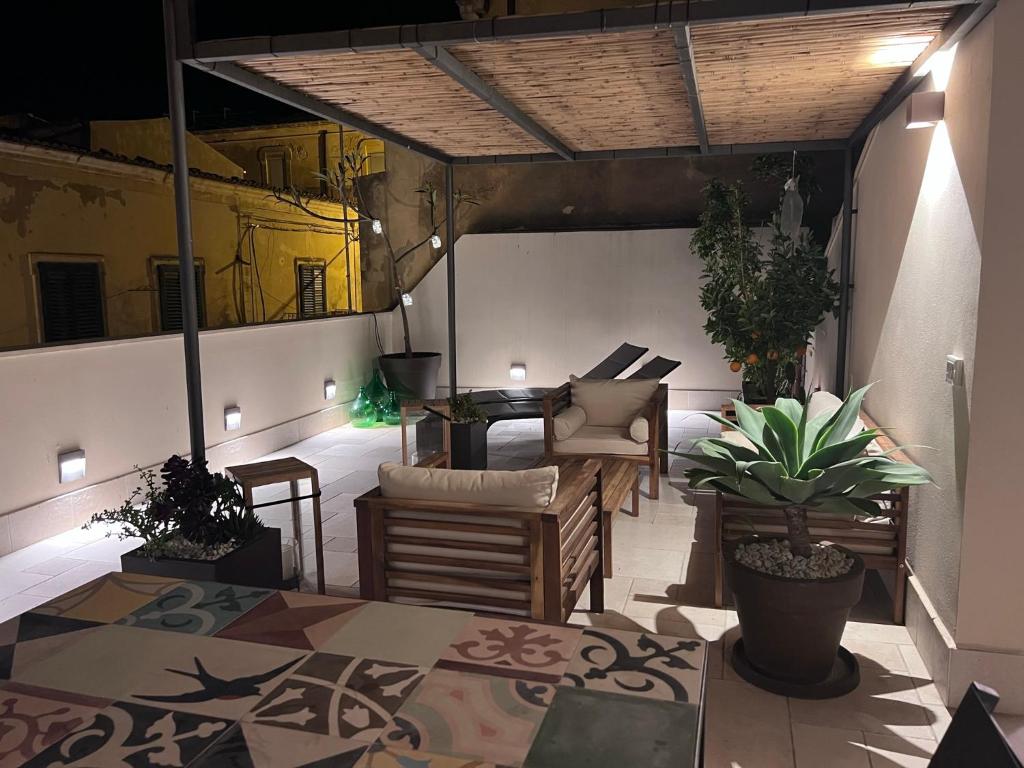 een patio met een tafel, stoelen en planten bij Sikelikós in Noto