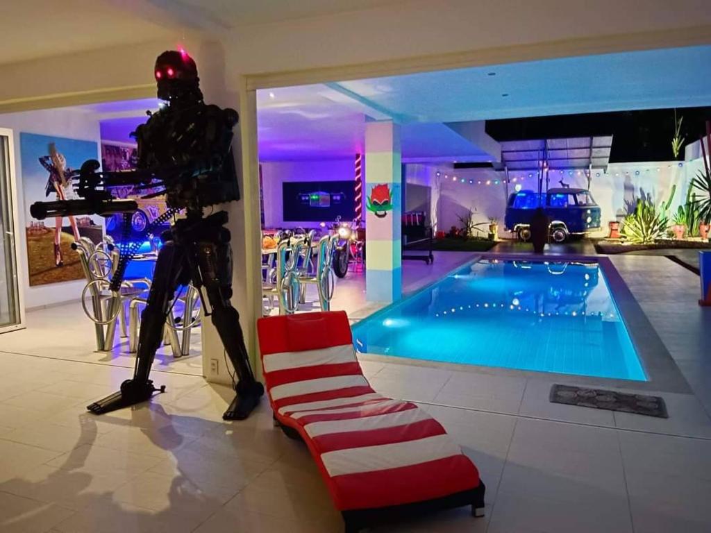 他朗的住宿－畫廊泳池度假屋，机器人站在游泳池旁边