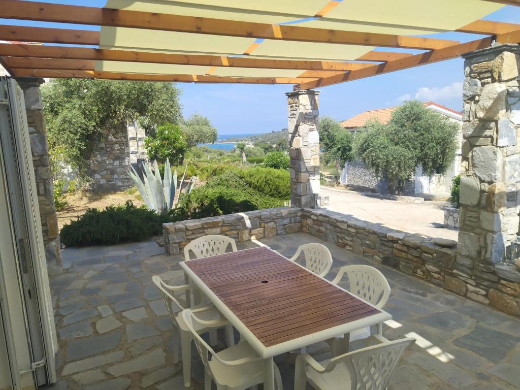 a wooden table and chairs under a wooden pergola at Ambra in Astris