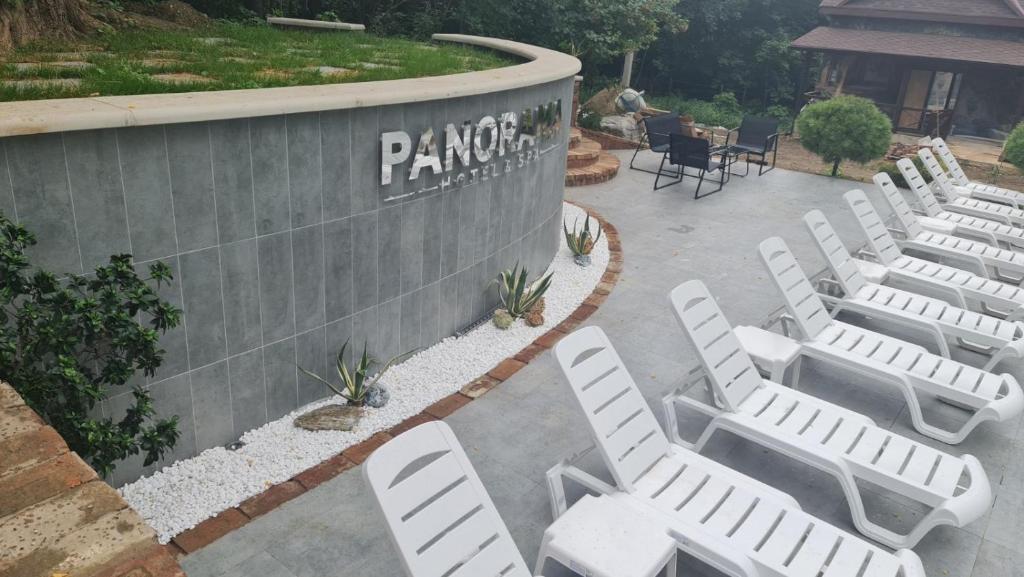 Banda białych krzeseł ustawionych pod ścianą w obiekcie Panorama Hotel & SPA w Czerniowcach