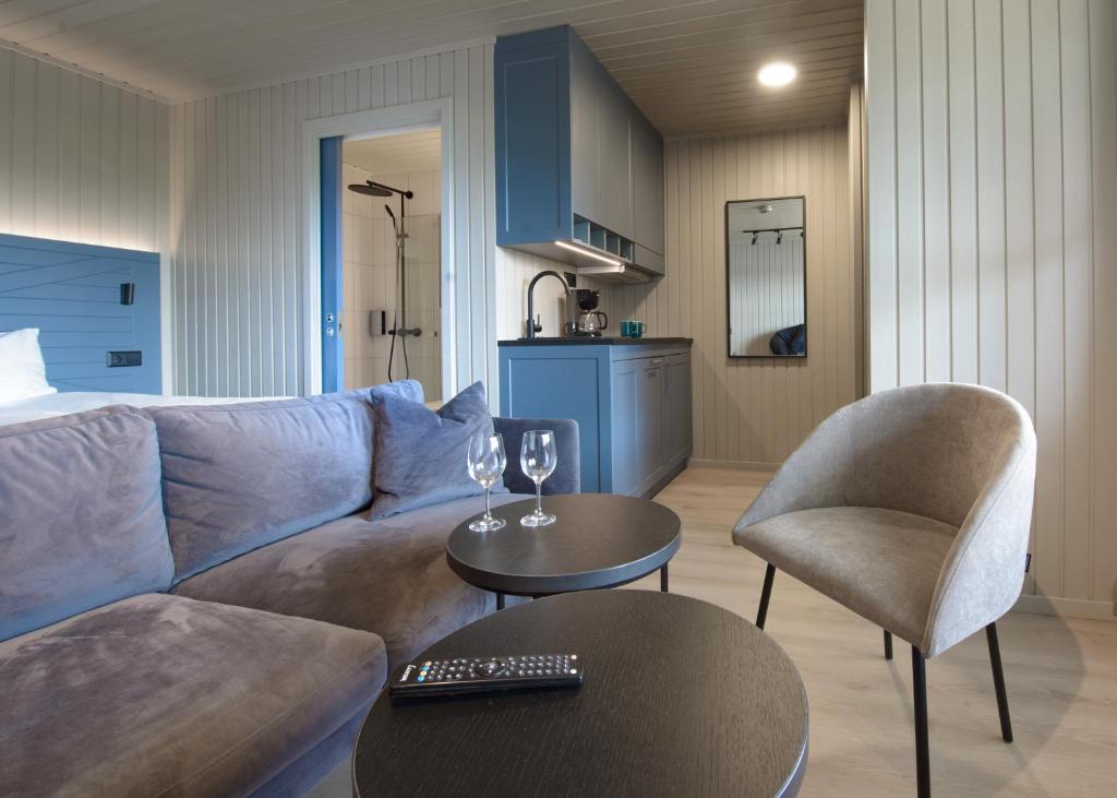 a living room with a couch and a table and chairs at Grønnbuene Rorbu Hotel in Andenes